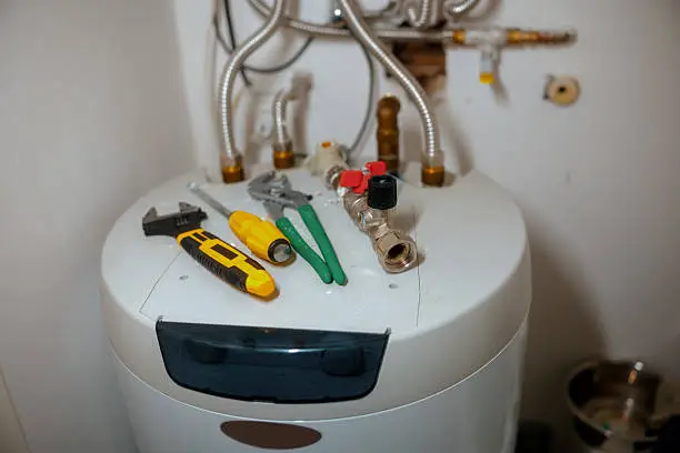 Technician repairing faulty water heater in Nipomo garage after sudden hot water loss